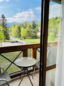 d'un balcon avec une table et des chaises et une vue. dans l'établissement Pod Bukami - Chill&SPA, à Szklarska Poręba