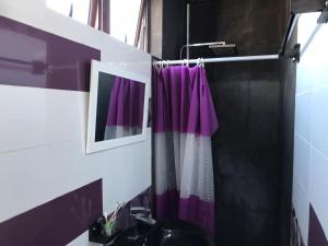 a bathroom with a purple shower curtain and a sink at 2 pokojový byt ve Flic en Flac Mauricius in Flic-en-Flac +43 photos