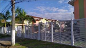 una valla de privacidad frente a una casa en Casa na Praia de Maitínga - Bertioga - SP, en Bertioga