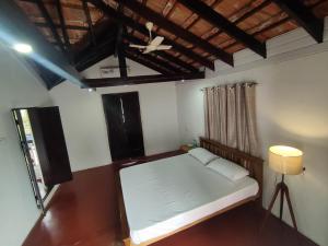 a small bedroom with a bed and a ceiling at SuKūn - Inhale Peace, Exhale Happiness in Kannur