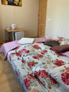 a bed with a flowered blanket on top of it at Rotušė in Trakai