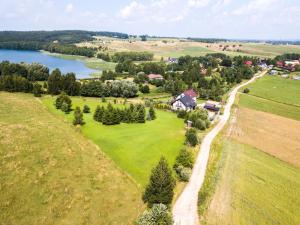 una vista aérea de una casa en una colina junto a un lago en EGZOTYCZNE HabibiSpa z JACUZZI pod chmurką przy cudownej PLAŻY, en Stare Juchy