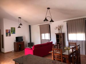 a living room with a red couch and a table at Chalet Ventura Conil in Cádiz