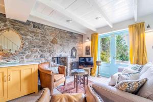 a living room with a couch and a stone wall at Secret Cottage in St Ives