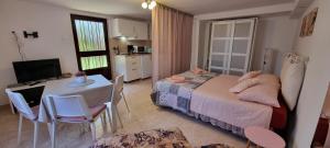 a bedroom with a bed and a table and a kitchen at App Maria 3 in Zambratija