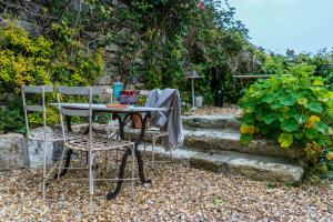 a table and two chairs sitting next to some stairs at Secret Cottage in St Ives