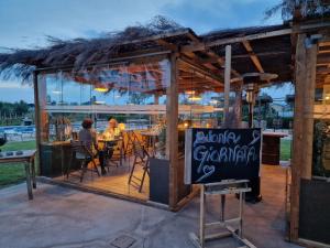 a restaurant with people sitting at tables and a sign at Agriturismo Sweet Cottage in Marina di Grosseto