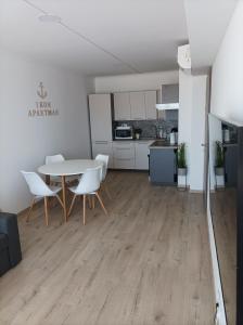 een woonkamer met een tafel en stoelen en een keuken bij Ikon in Siófok