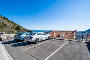 zwei Autos auf einem Parkplatz mit Aussicht geparkt in der Unterkunft Hillside Apartments in Dubrovnik