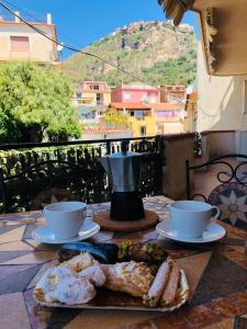 a table with two cups and a plate of food at La casa di Marilena in Taormina