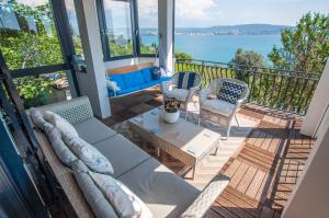 a living room with a couch and chairs on a balcony at Sea View Apartments Debeli Rtič in Ankaran