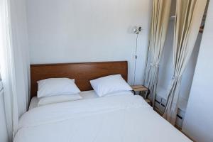 2 Betten in einem kleinen Zimmer mit weißer Bettwäsche in der Unterkunft Grand Seaview Retreat - walk to the beach in Néoi Epivátai