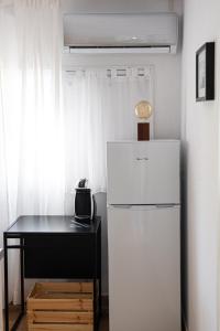 ein weißer Kühlschrank und ein Schreibtisch in einem Zimmer in der Unterkunft Grand Seaview Retreat - walk to the beach in Néoi Epivátai