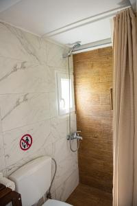 ein Badezimmer mit Toilette und Dusche in der Unterkunft Grand Seaview Retreat - walk to the beach in Néoi Epivátai
