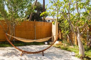a hammock in a garden next to a fence at Grand Seaview Retreat - walk to the beach in Neoi Epivates