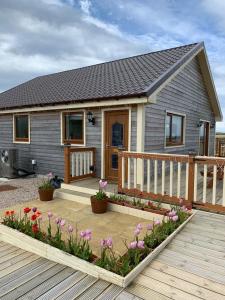 a small house with flowers in front of it at Riverside Chalet Borve Isle of Lewis in Borve