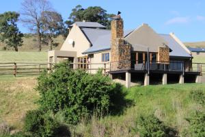 a house on a hill in a field at Wetlands Game Lodge in Wakkerstroom