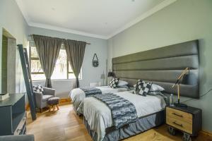 a bedroom with a large bed and a chair at Wetlands Game Lodge in Wakkerstroom