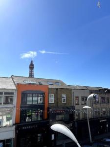 un groupe de bâtiments avec une tour d'horloge en arrière-plan dans l'établissement Winter Gardens North Pier 2 Bed, à Blackpool 2 autres photos