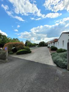 a road with a house and a sky with clouds at The Originals City, Hôtel Solana, Niort Est MendesFrance in Niort