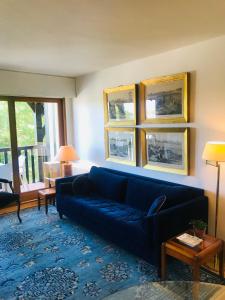 uma sala de estar com um sofá azul e uma mesa em le Pullman em Deauville