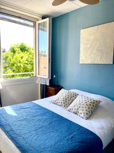 Dormitorio azul con cama y ventana en Grand Hôtel De La Poste, en Salon-de-Provence