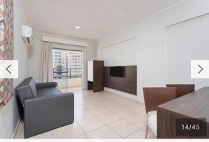 a living room with a television and a table and chairs at Apartamento em Resort Olímpia in Olímpia