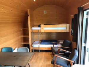 een kamer met 2 stapelbedden en een tafel en stoelen bij Tiny House de Wood Lodge in Ootmarsum
