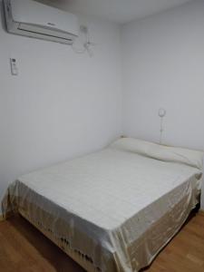 a bed in a room with a white wall at El Jacal de San Pedro in San Pedro