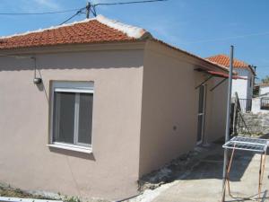 a small house with a window on the side of it at George house in Theológos +15 photos