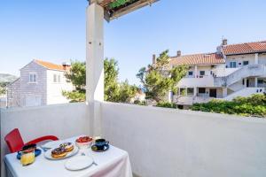 una mesa con comida en el balcón con vistas a un edificio en M2 Apartment Dubrovnik, en Dubrovnik