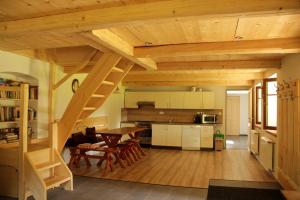 a kitchen and dining room with a wooden staircase in a house at Chalupa Nové Losiny in Nové Losiny