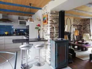 a kitchen with a bar with stools and a stove at maison piscine privée proche de Rodez in Cassagnes-Bégonhès