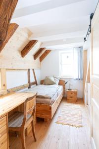 - une chambre avec un lit et un bureau dans l'établissement Gästehaus Großhöchberg, à Spiegelberg