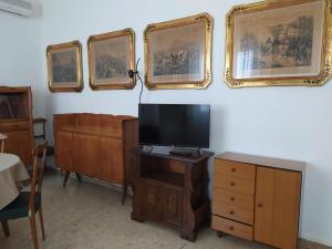 sala de estar con TV, tocador y cuadros en la pared en La Terrazza su Monza Casa Vacanze, en Monza