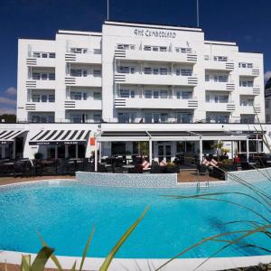 a hotel with a swimming pool in front of a building at Cumberland Hotel - OCEANA COLLECTION in Bournemouth