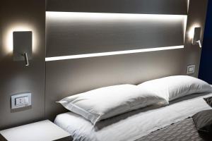 a bed with white sheets and pillows in a room at That's Amore Accommodation Tropea in Tropea