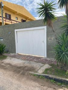 a white garage door on the side of a building at Casa agradável com lareira in Chuí