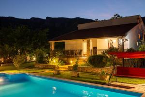 BunaにあるVilla Ganaの家の前にプールがある家