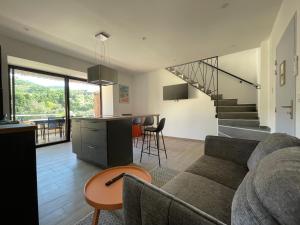 a living room and kitchen with a couch and a table at Ibanova Appartements in Collioure