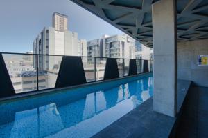 a swimming pool on the roof of a building at Queen Bed Luxury Parisian Paradise with Amazing City Views, Spa, Gym, Steam & Sauna Rooms in Adelaide