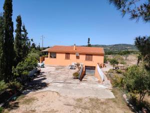 una casa naranja en medio de un campo en Villa dei Ginepri, en Badesi