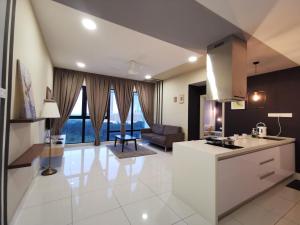 a kitchen and living room with a couch and a table at Mid Valley Southkey Mosaic Cozy Suite at Johor Bahru in Johor Bahru