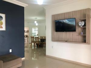 uma sala de estar com uma televisão de ecrã plano na parede em Casa em bairro nobre - Caçari em Boa Vista