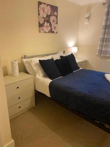 a bedroom with a bed and a dresser with a blue blanket at global relocation 2 Bed Apt Near Hatfield Station Free Parking in Hatfield