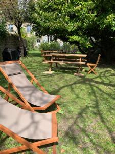a couple of chairs and a picnic table in the grass at Grand appartement tout confort en plein coeur d'Arbois in Arbois