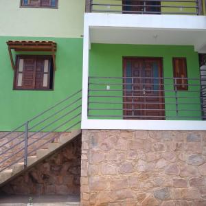 a green building with a staircase next to a stair case at Casas Bela da Chapada in Lençóis