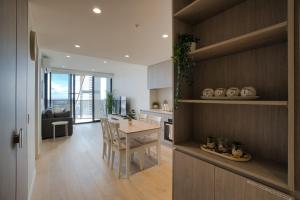 a kitchen and dining room with a table and chairs at King Bed Luxury CBD Coastal Room with Amazing City Views, Spa, Gym, BBQ, Steam & Sauna Rooms in Adelaide