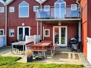 a patio with a wooden table and a balcony at 6 person holiday home in Hadsund-By Traum in Hadsund