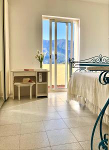 a bedroom with a bed and a table and a window at Relax Maratea in Maratea